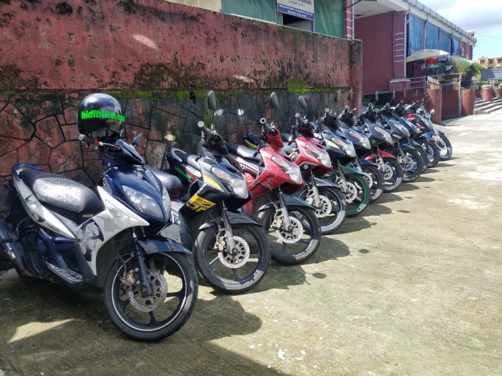 A row of motorcycles parked on concreteDescription automatically generated